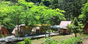 eine Gruppe von Häusern mit Bäumen im Hof in der Unterkunft Ryujin Village Oku-Komatagawa Bungalow - Vacation STAY 42249v in Ōkuma