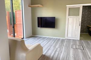 a living room with a flat screen tv on the wall at Yamaga City - Camp - Vacation STAY 42290v in Kurize
