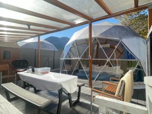 a yurt with a table and chairs on a deck at SPRINGS VILLAGE Ashigara-Tanzawa Hot Spring Resort & Glamping - Vacation STAY 42321v in Oyama