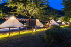 una fila de tiendas de campaña en un campo por la noche en SPRINGS VILLAGE Ashigara-Tanzawa Hot Spring Resort & Glamping - Vacation STAY 42313v, en Oyama