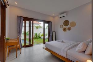 une chambre avec un lit, un bureau et une fenêtre dans l'établissement Villa Polo - Padonan near Canggu with Private Pool, à Dalung