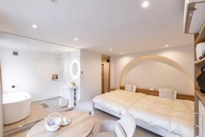 a bedroom with a large bed and a tub and a sink at R;MOGAMI - Vacation STAY 25489v in Kiyokawa