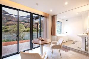 a living room with a table and chairs and a bathroom at R;MOGAMI - Vacation STAY 25489v in Kiyokawa