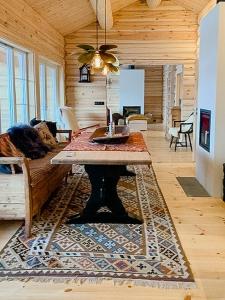 ein Wohnzimmer mit einem Tisch auf einem Teppich in der Unterkunft Log Cabin With Panoramic Views Of Hallingskarvet in Hovet