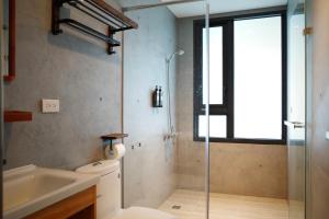 a bathroom with a shower and a toilet and a sink at 春喃日光 Whispring Inn in Hengchun