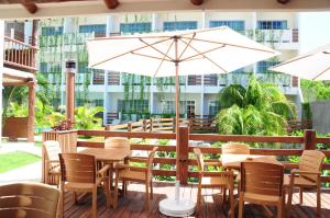 a patio with tables and chairs and an umbrella at Posada Sian Kaan Playa del Carmen - Wellness Oriented Hotel in Playa del Carmen +33 photos