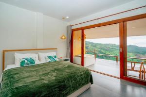 a bedroom with a large bed and a balcony at Baan Rai good view cafe&Resort in Mae Suai