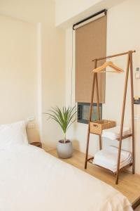 a bedroom with a bed and a ladder and a plant at 春喃日光 Whispring Inn in Hengchun