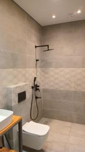 a bathroom with a shower and a toilet and a sink at IO House in Urekis Sadguri
