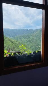 una finestra con vista sulle montagne di Mayank homestay shimla a Shimla