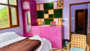a room with a bed and a pink wall at Mayank homestay shimla in Shimla