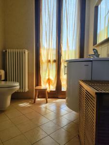 PusianoにあるDelizioso appartamento al lagoのトイレ、洗面台、窓のあるバスルーム +5枚の写真