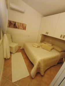 a small bedroom with two beds and a chair at Villetta Isor con piscina in Costa Paradiso