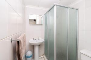 a bathroom with a glass shower and a sink at Seagull 507 in Margate