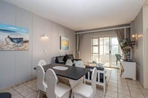 a dining room with a table and white chairs at Seagull 507 in Margate