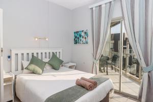 a bedroom with a large bed and a balcony at Seagull 507 in Margate +7 photos