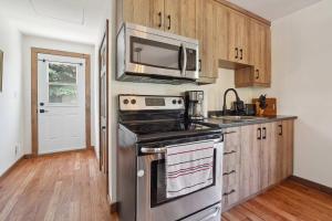 a kitchen with a stove and a microwave at Le Mystic - Lake Taureau in Saint-Michel-des-Saints +23 photos