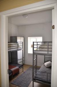a room with three bunk beds and a window at The farmhouse at Pilgården in Simrishamn