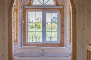 - une fenêtre dans une chambre avec un matelas en face dans l'établissement Santa Beach Pension, à Kangmun