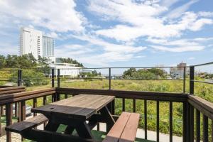 - une table de pique-nique en bois sur un balcon avec vue dans l'établissement Santa Beach Pension, à Kangmun 14 autres photos