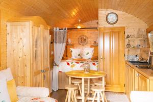 a room with a small table and a bed in a cabin at Roulotte Les Deux Geais in Sainte-Opportune-du-Bosc