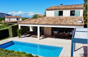a house with a swimming pool in front of a house at Maison Louise in Malaucène