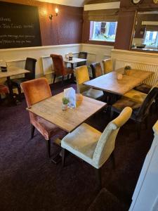 a restaurant with wooden tables and chairs and a chalkboard at The Bay Horse Inn in Green Hammerton