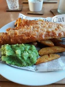 a plate of food with fish sticks and guacamole and potatoes at The Bay Horse Inn in Green Hammerton