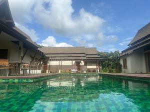 a swimming pool in front of a house at Villa Mae Hong Son in Mae Hong Son