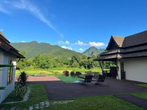 a house with a patio with chairs and a pond at Villa Mae Hong Son in Mae Hong Son