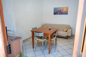 a table and chairs in a living room with a couch at Appartamento GG - Palmi in Palmi