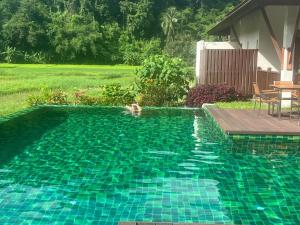 a person swimming in a swimming pool at Villa Mae Hong Son in Mae Hong Son