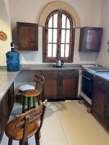 锡瓦Siwa Spot的配有木制橱柜、桌子和椅子的厨房