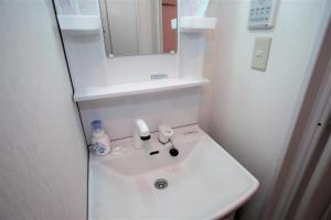 a bathroom with a white sink and a mirror at Numero Uno Tokyo - Vacation STAY 25720v in Tokyo +12 photos