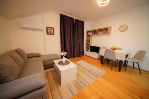 a living room with a couch and a table at Apartman SAN in Banja Koviljača