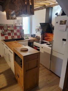 a kitchen with a white refrigerator and a stove at The Cozy Collo House in Collobrières