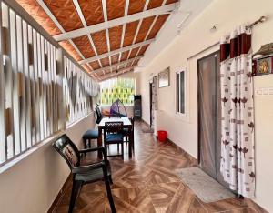 a hallway with a table and chairs and windows at Nanis Villa in Anantapur