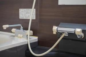 a hose hooked up to a toilet in a bathroom at STAY IN ASAHIBASHI - Vacation STAY 26632v in Asahikawa +29 photos