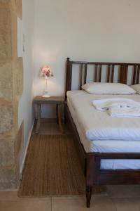 a bedroom with a bed and a table with a lamp at Cretan cottage of 1900 with beautiful olive yard in Kissamos