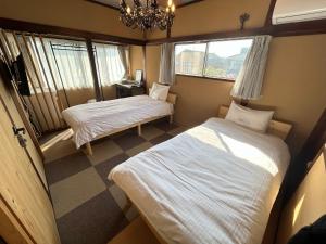 a bedroom with two beds and a chandelier at Classy Busshozan - Vacation STAY 15858 in Takamatsu +26 photos