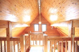 an inside view of a wooden building with a ceiling at Tokashiki Guest House in Tokashiki