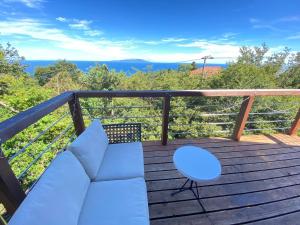 a balcony with a couch and a chair on a deck at Spa&View COZY HOUSE - Vacation STAY 36902v in Okawa