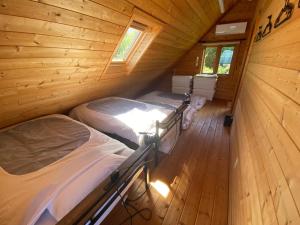 two beds in a wooden cabin with a dog standing between them at Spa&View COZY HOUSE - Vacation STAY 36902v in Okawa