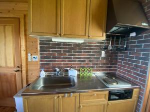 a kitchen with a sink and a brick wall at Spa&View COZY HOUSE - Vacation STAY 36902v in Okawa +15 photos