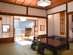 a living room with a table and a chair at Guest house & Sauna MORI - Vacation STAY 29151v in Kushimoto
