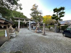 a gravel driveway with an arch and a car parked at Guest house & Sauna MORI - Vacation STAY 29151v in Kushimoto