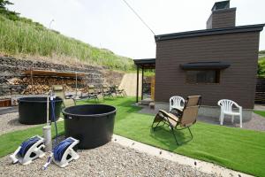 a yard with chairs and a house with grass at Private sauna stay Shinori - Vacation STAY 34530v in Hakodate