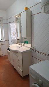 a white bathroom with a sink and a mirror at Beach villa La Genziana in Parghelia