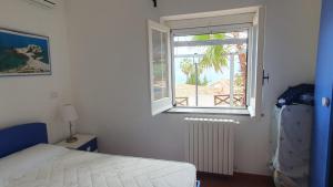 a bedroom with a bed and a window at Beach villa La Genziana in Parghelia