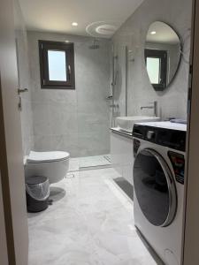 a bathroom with a washing machine and a toilet at Poseidon 77B Luxury Residences in Loutraki +23 photos